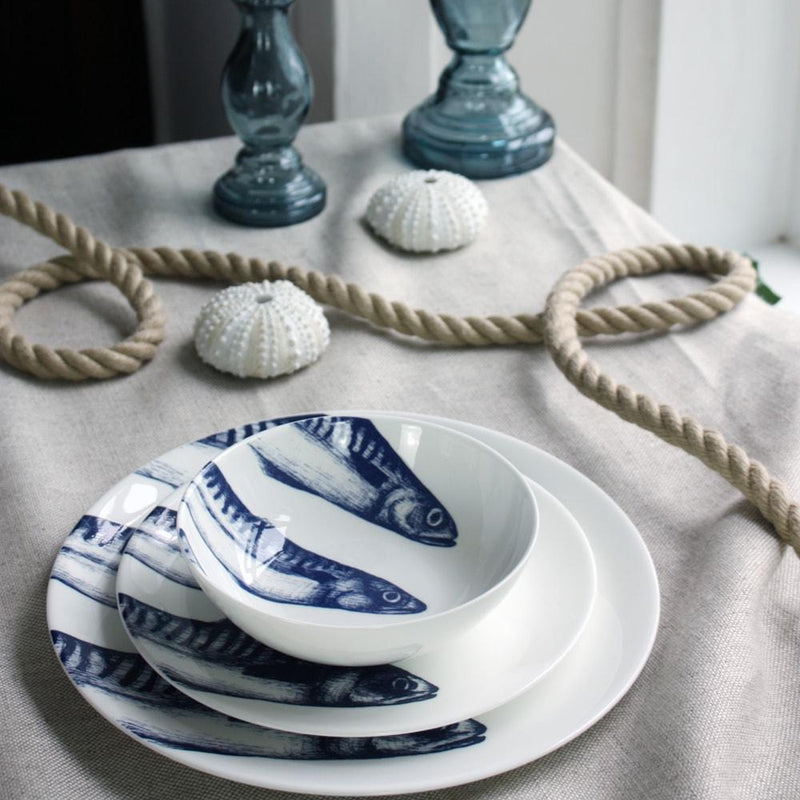 Bone china Mackerel Heads stack of bowl,side and dinner plate on a tablecloth.Also on the table is a bone china jug,a couple of glass candlesticks and other table decorations