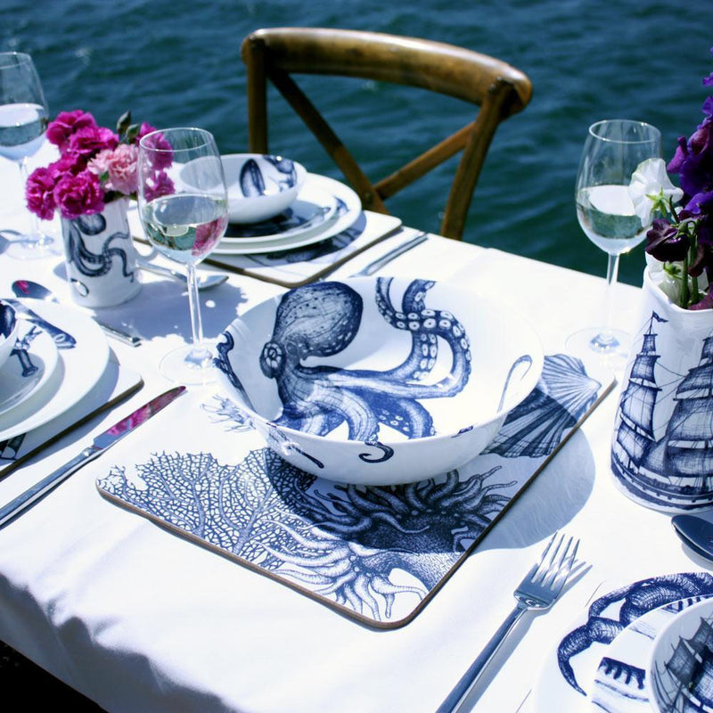 Serving bowl in Bone China in our Classic range in Navy and white in the October design on a white tablecloth on a table setting in the background you can see the sea