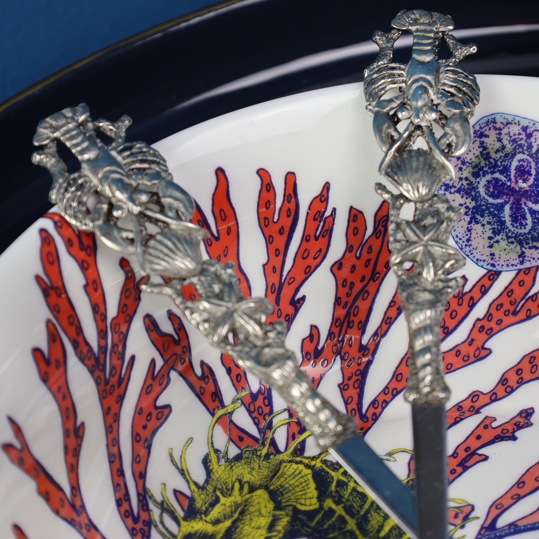 Extreme close up of Pewter Shell & Lobster Salad Servers  in Reef serving bowls