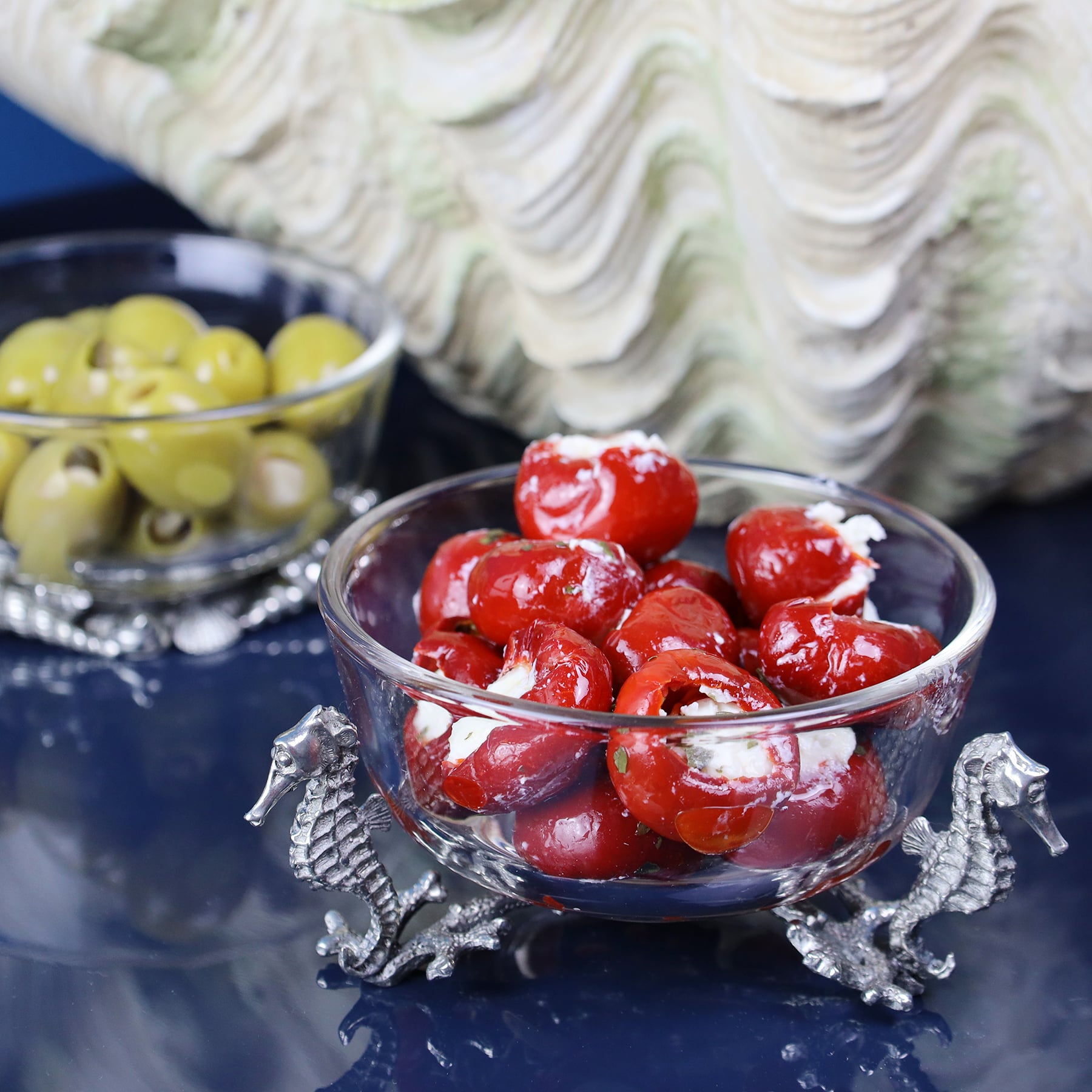 Pewter Seahorse Glass Bowl  containing olives next to a large shell