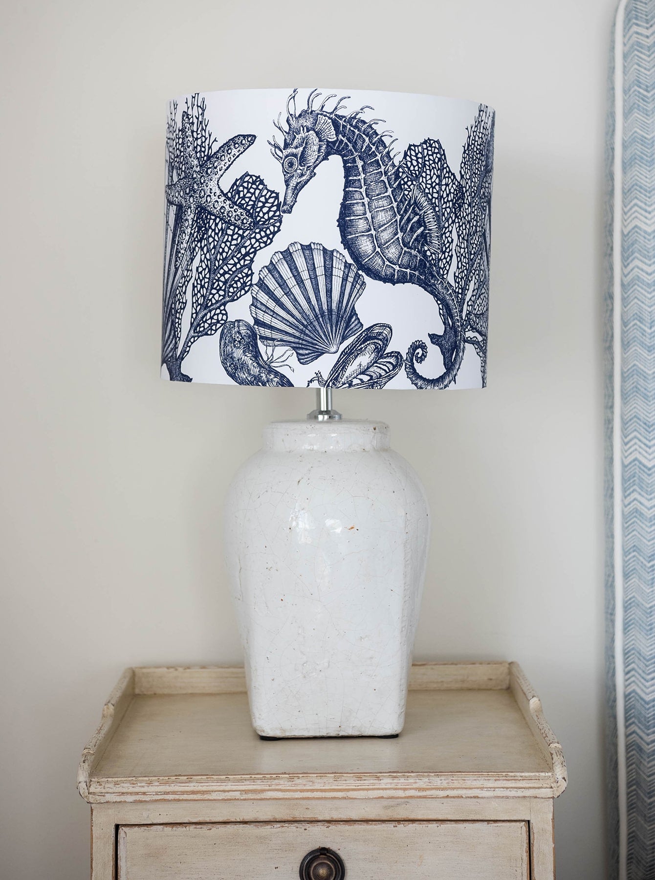 Our Classic Navy Seahorse design on a white background on a white lampbase placed on a side table.