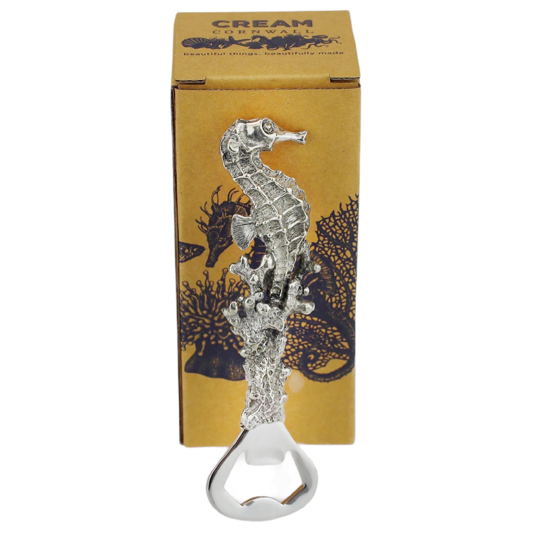 Pewter Seahorse Bottle Opener on its side in front of a cream cornwall box