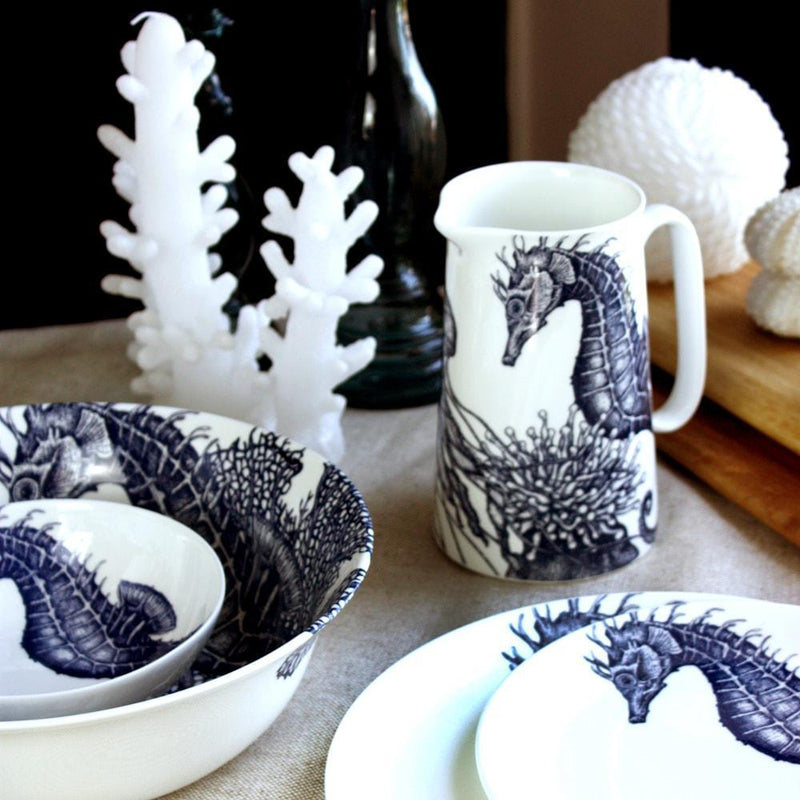Serving bowl in Bone China in our Classic range in Navy and white in the Octopus design placed with other pieces of seahorse china.Central is a Seahorse Jug,a coral candle and shells and wooden chopping boards