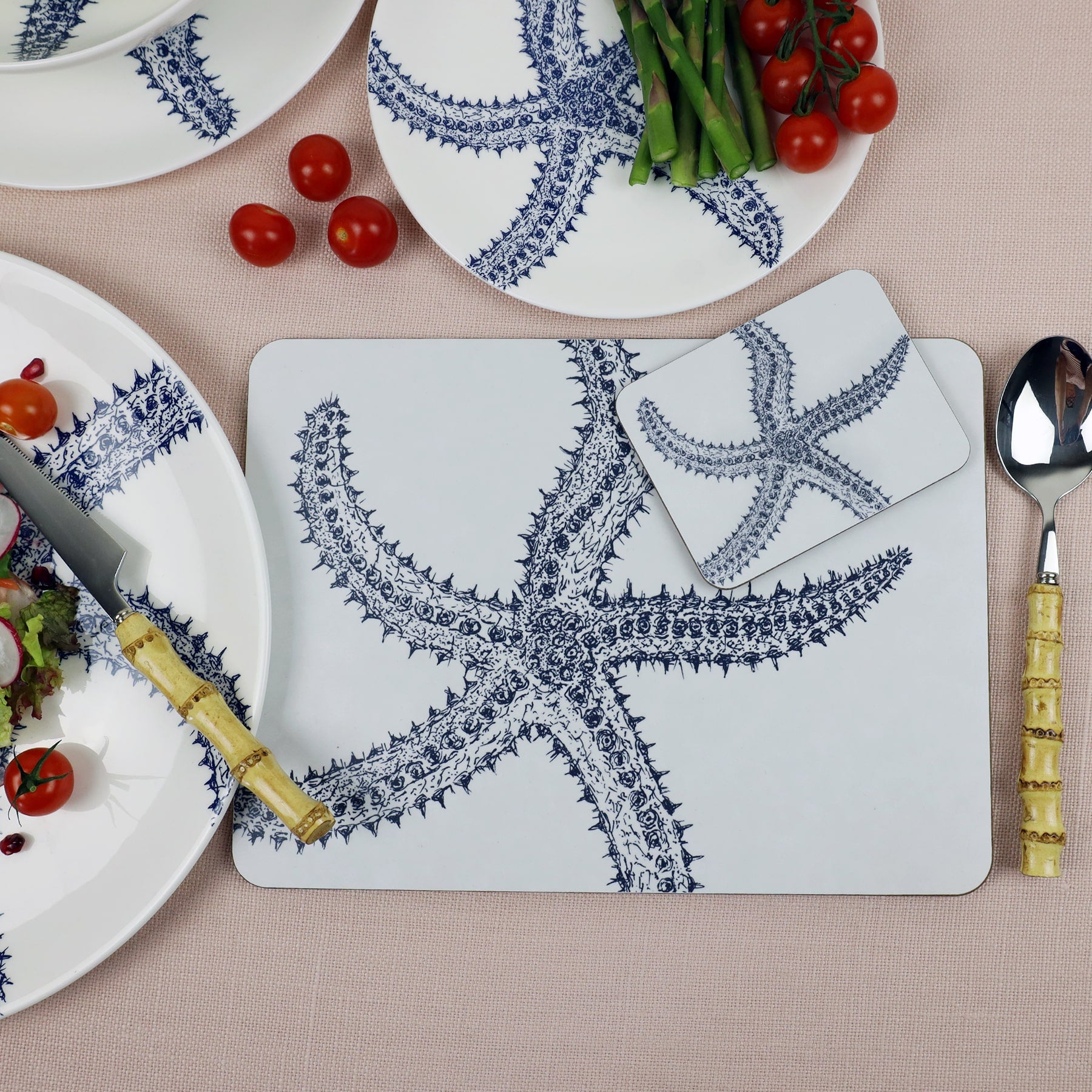 Starfish Placemat and matching Coaster placed on a table with bamboo cutlery.On the table is other tableware items