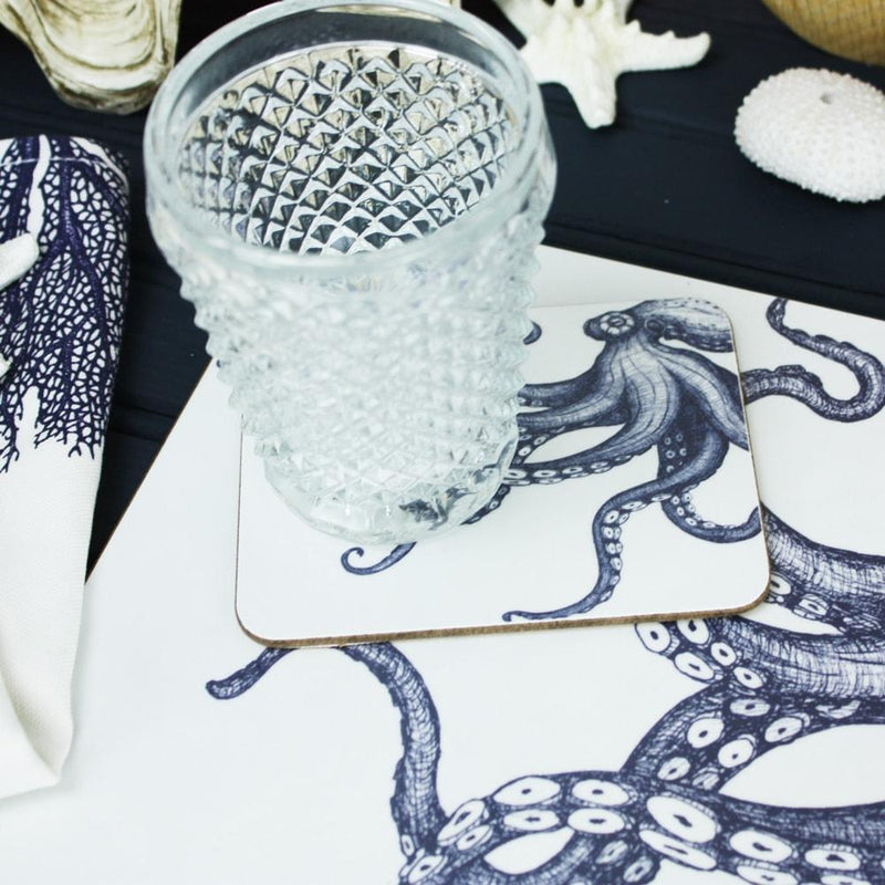 Octopus Placemat and matching Coaster placed on a table with a clear glass on top.o the table were other tableware
